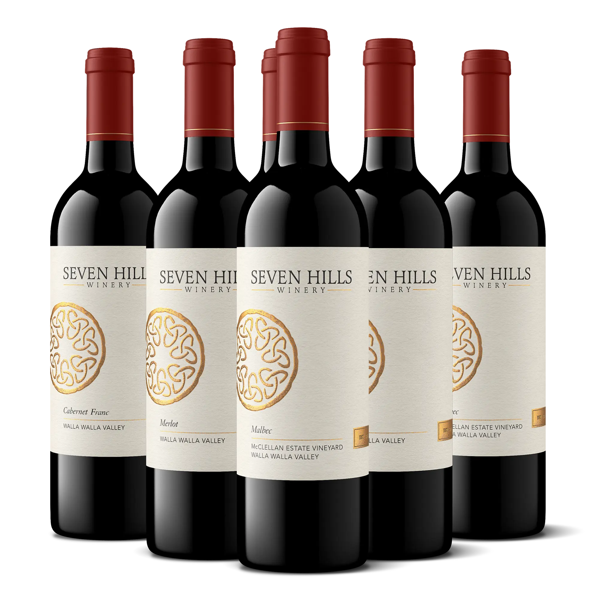 Five bottles of Seven Hills Winery, celebrated as Washington’s Finest Wine, with cream labels, gold circular logos, and red tops are arranged in a staggered formation on a white background—making an impressive wine gift for any occasion.
