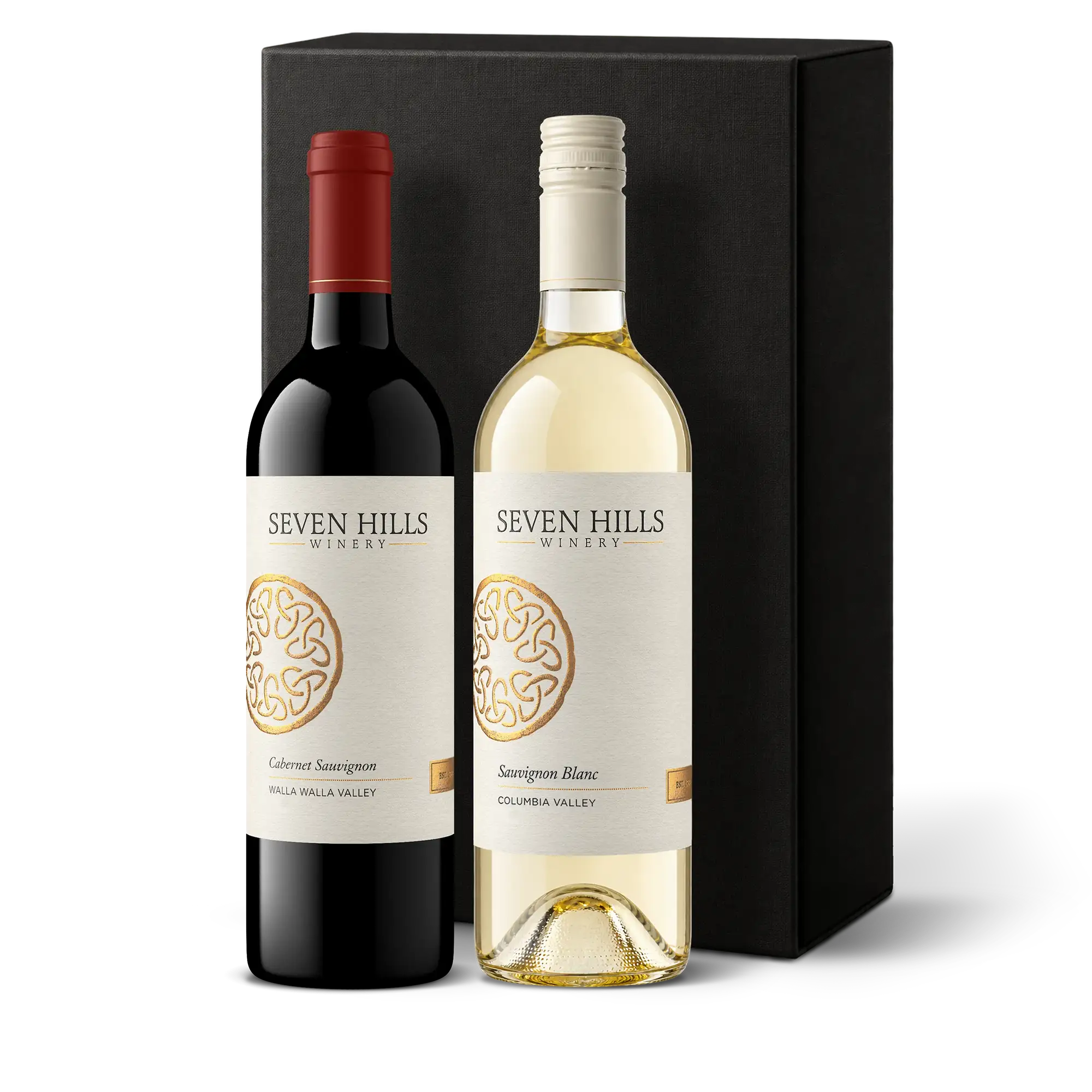 Two bottles of Washington’s finest wine—one red, one white—stand in front of a sleek black box. The labels show Seven Hills Winery with a gold circular design and the wine types: Cabernet Sauvignon and Sauvignon Blanc, making this an elegant wine gift for any occasion.