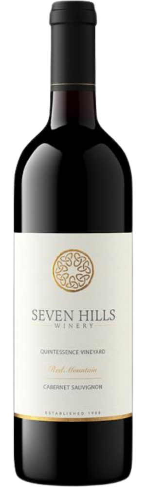 A bottle of Seven Hills Winery red wine with a cream label featuring gold and black text. The label reads Quintessence Vineyard, Red Mountain, Cabernet Sauvignon. The bottle has a dark neck and a gold-trimmed seal.